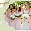 A group of women in pink dresses holding bouquets of white roses for a wedding photo.