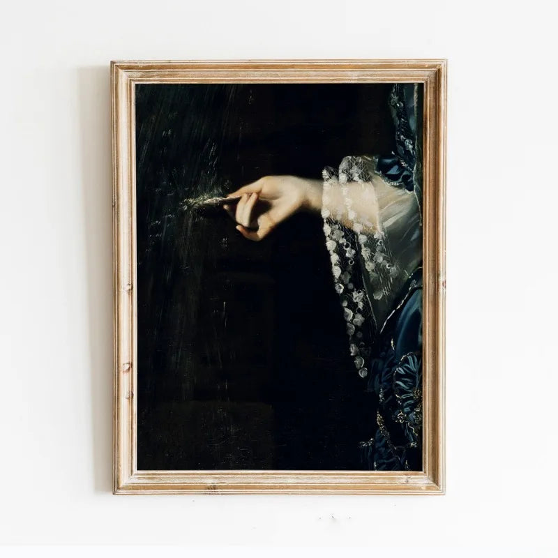 A framed dark academia vintage canvas wall art print featuring a moody Victorian print of a hand painting on a dark backgroun