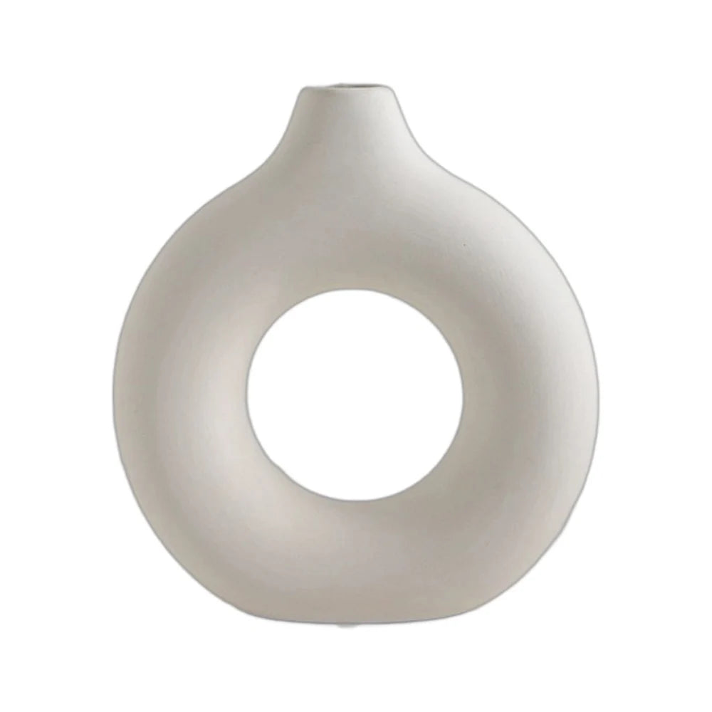 A smooth, off-white ceramic circular vase with a rounded, organic shape.