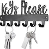 A black wall-mounted metal key holder with hooks and several keys.