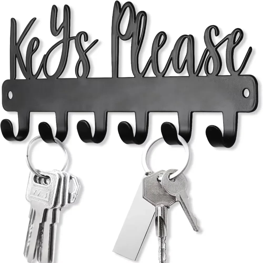 A black wall-mounted metal key holder with hooks and several keys.