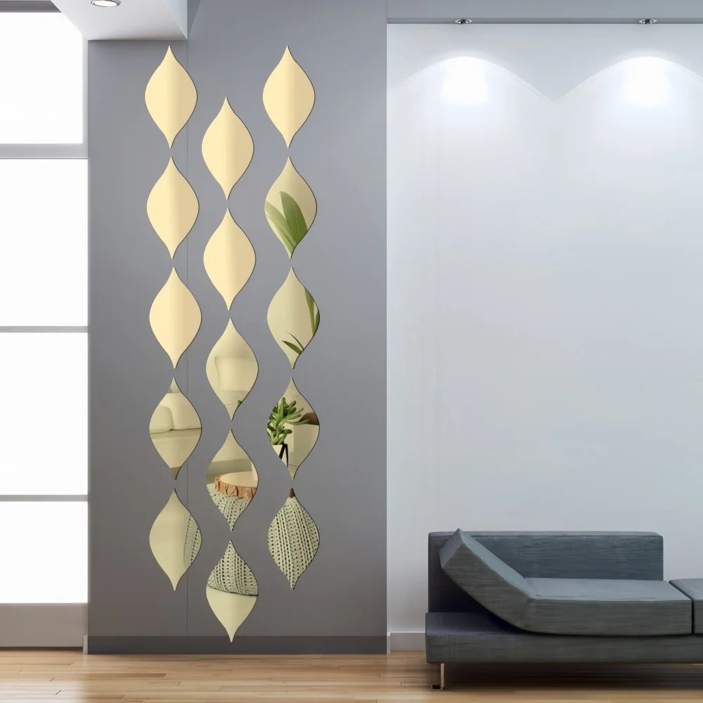 A vertical arrangement of ten gold reflective acrylic droplet mirror stickers on a gray wall.
