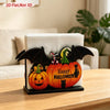 Halloween pumpkin ghost tissue box cover with black bat cutouts and a green leaf design on a wooden table.