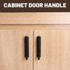 Close-up of two black cabinet door handles on a light wood cabinet drawer.