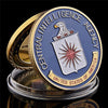 Gold-plated CIA challenge coin featuring an eagle emblem and text set in a protective case.