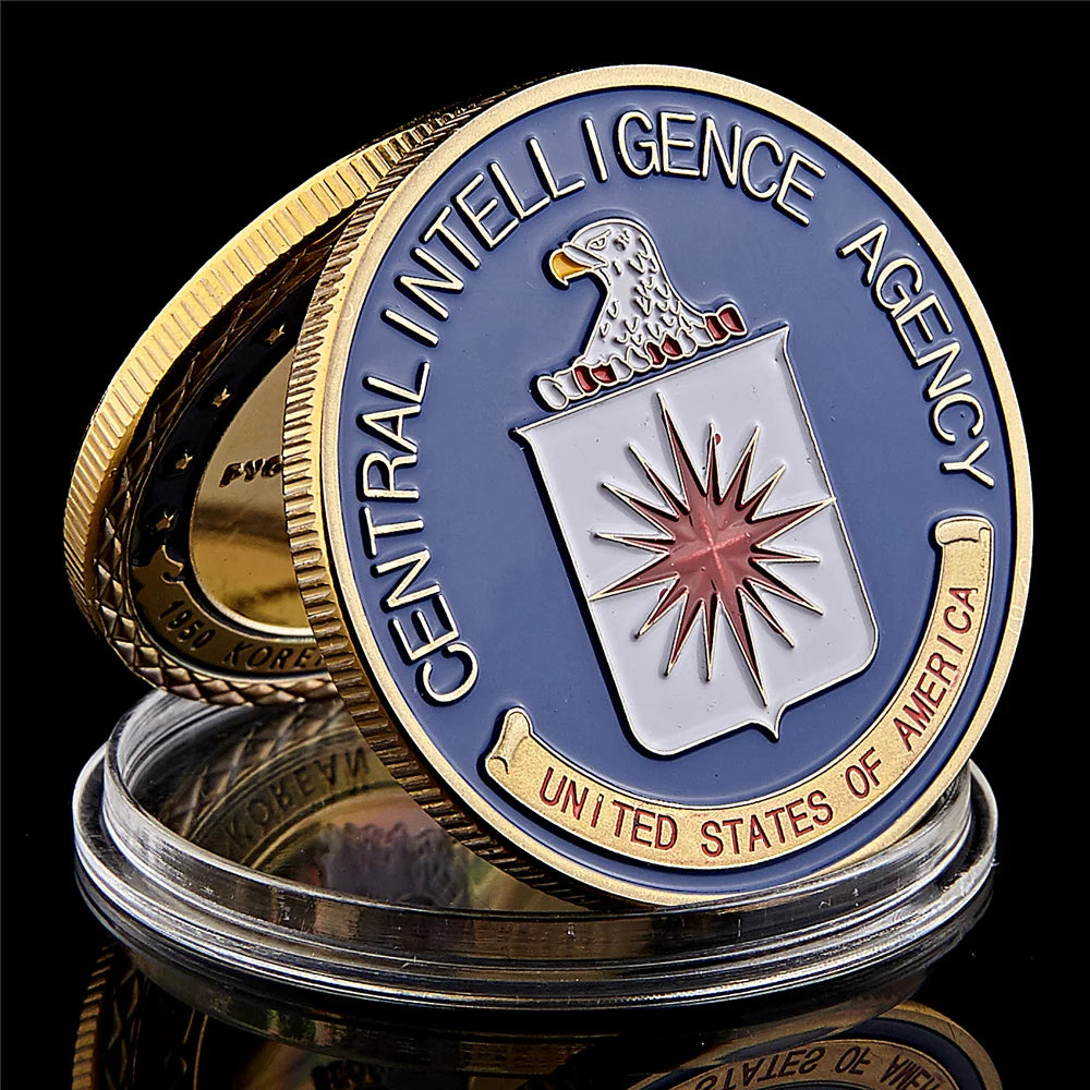 Gold-plated CIA challenge coin featuring an eagle emblem and text set in a protective case.