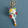Handcrafted crochet cat keychain pendant with purple and yellow fur and a gold ring.