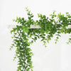 Green artificial simulation vine garland hanging against a white background.