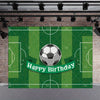 A green soccer field backdrop featuring a soccer ball and a Happy Birthday banner on a brick wall.