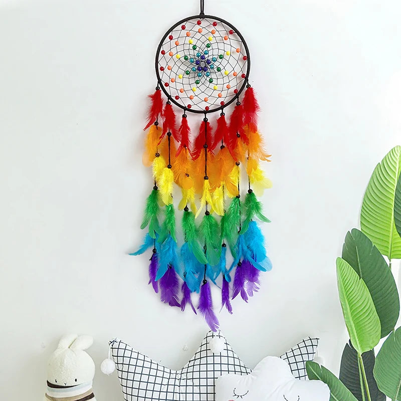A colorful feather dream catcher pendant with multicolored feathers and a beaded hoop hanging against a white background.