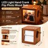 A wooden hand crank flip photo box with an LED light illuminating a couple's picture.