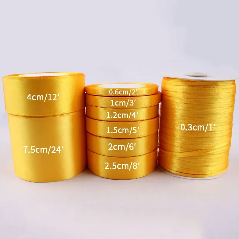 Rolls of gold yellow satin ribbon in various widths and lengths for crafts and gift wrapping