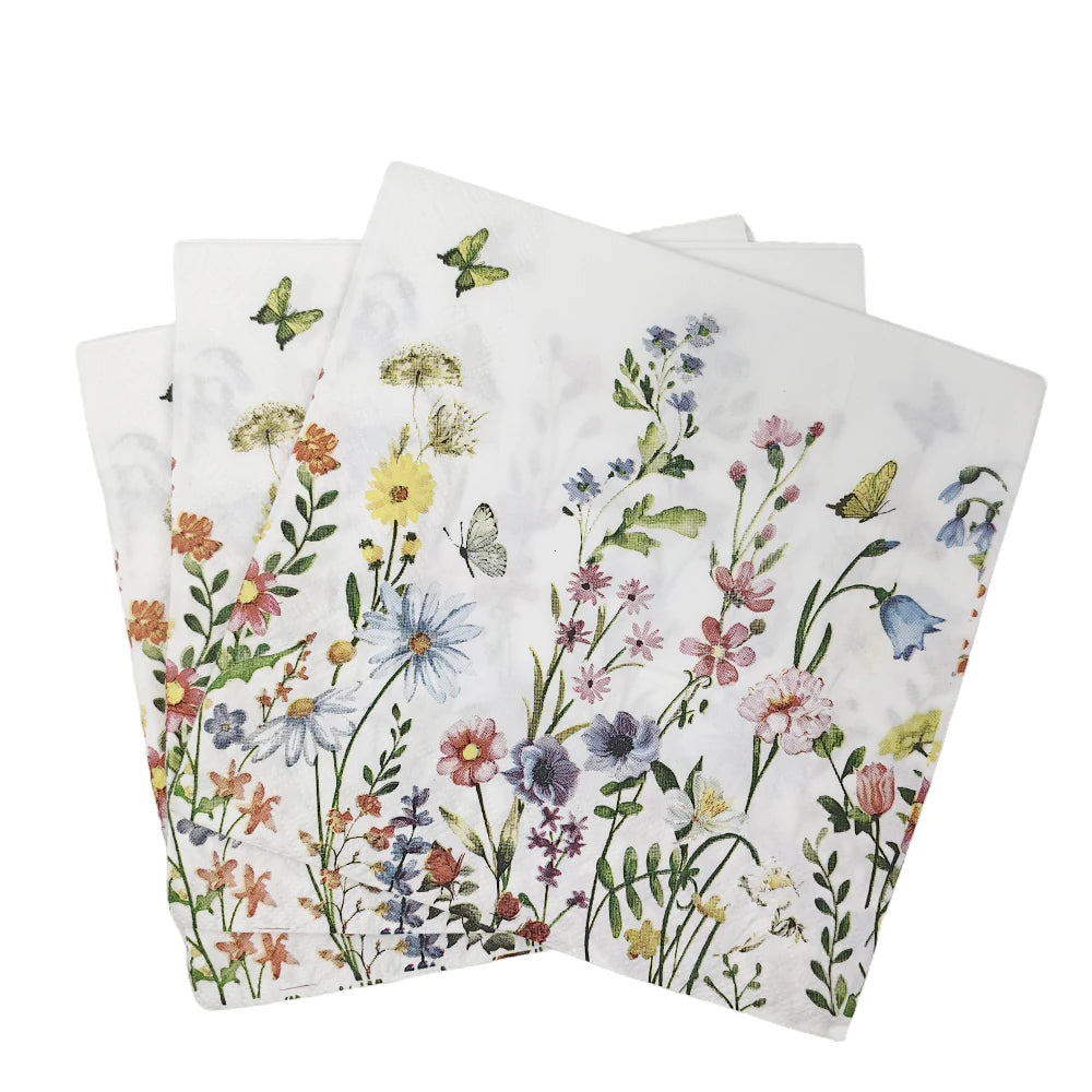 A stack of white napkins featuring a watercolor floral pattern with pink, purple, and green flowers.
