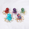 Four crystal octopus statues in various colors including red purple green and blue