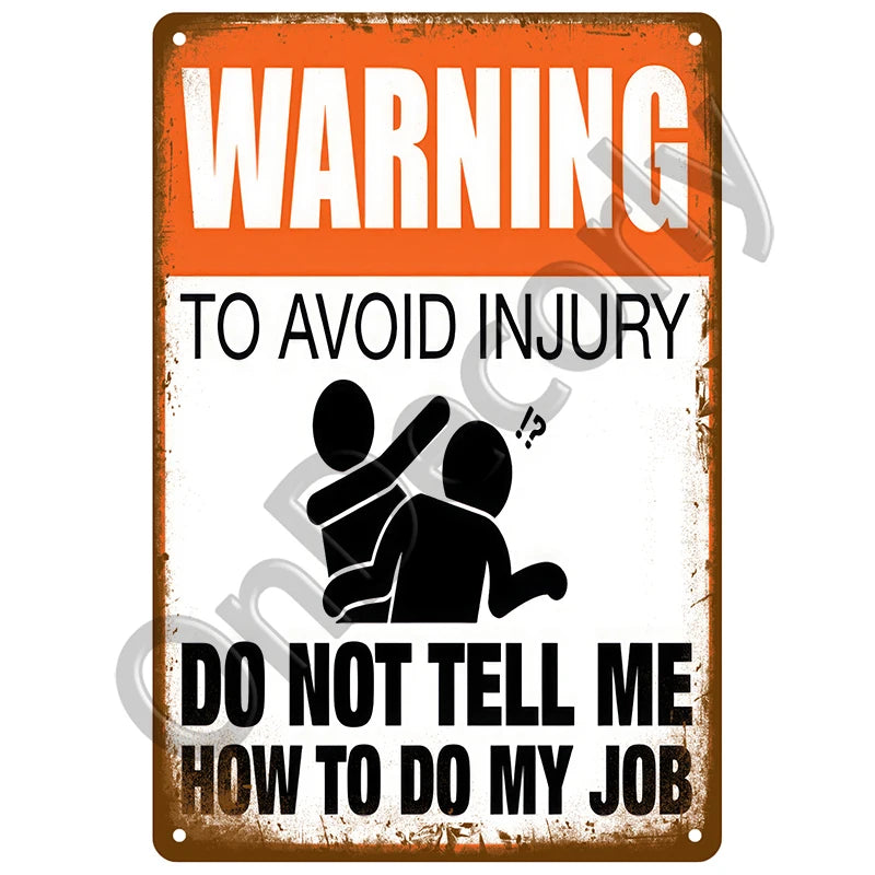An orange and white vintage metal sign with the text WARNING TO AVOID INJURY DO NOT TELL ME HOW TO DO MY JOB
