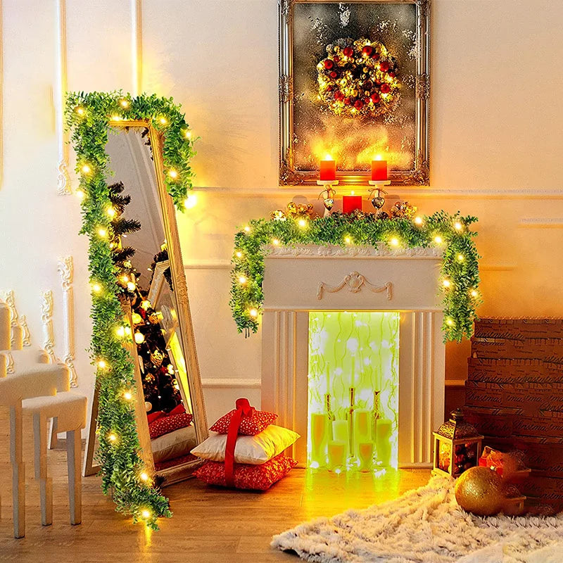 Guirlande d'eucalyptus artificielle décorant une cheminée avec bougies et verdure.