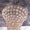 A close-up of a crystal gold flower vase with an intricate, textured pattern on the body.