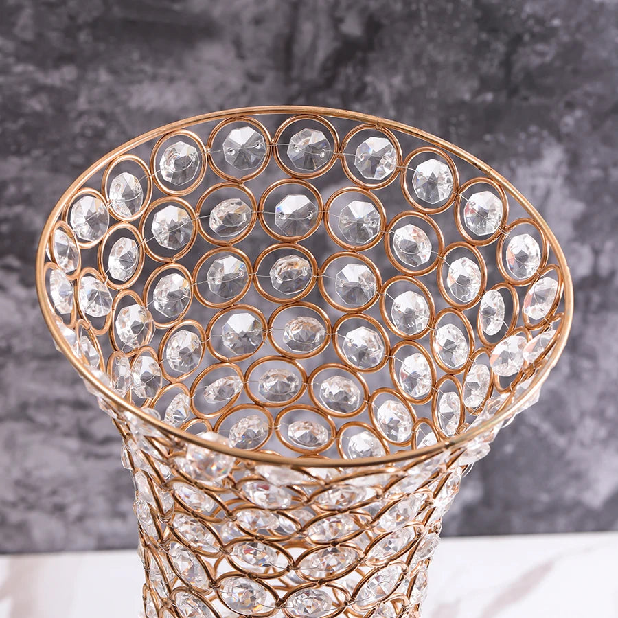 A close-up of a crystal gold flower vase with an intricate, textured pattern on the body.