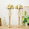 A set of gold crystal vases with floral arrangements displayed on a wooden table.
