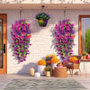 A vertical display of vibrant purple and pink artificial morning glory garlands hanging against a white wall.