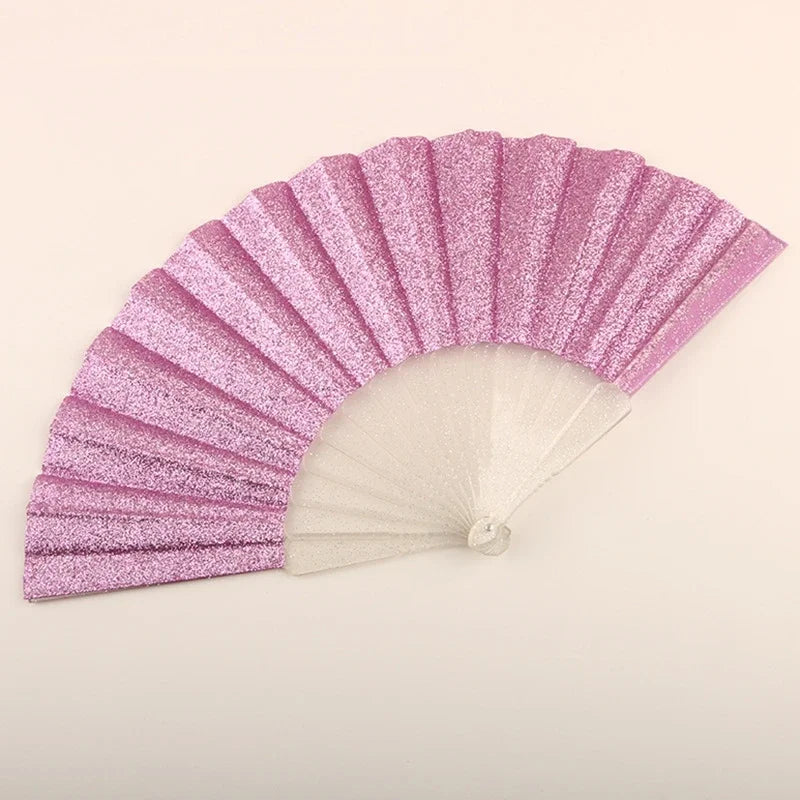 A pink glitter folding fan with transparent ribs shown in a fan shape.