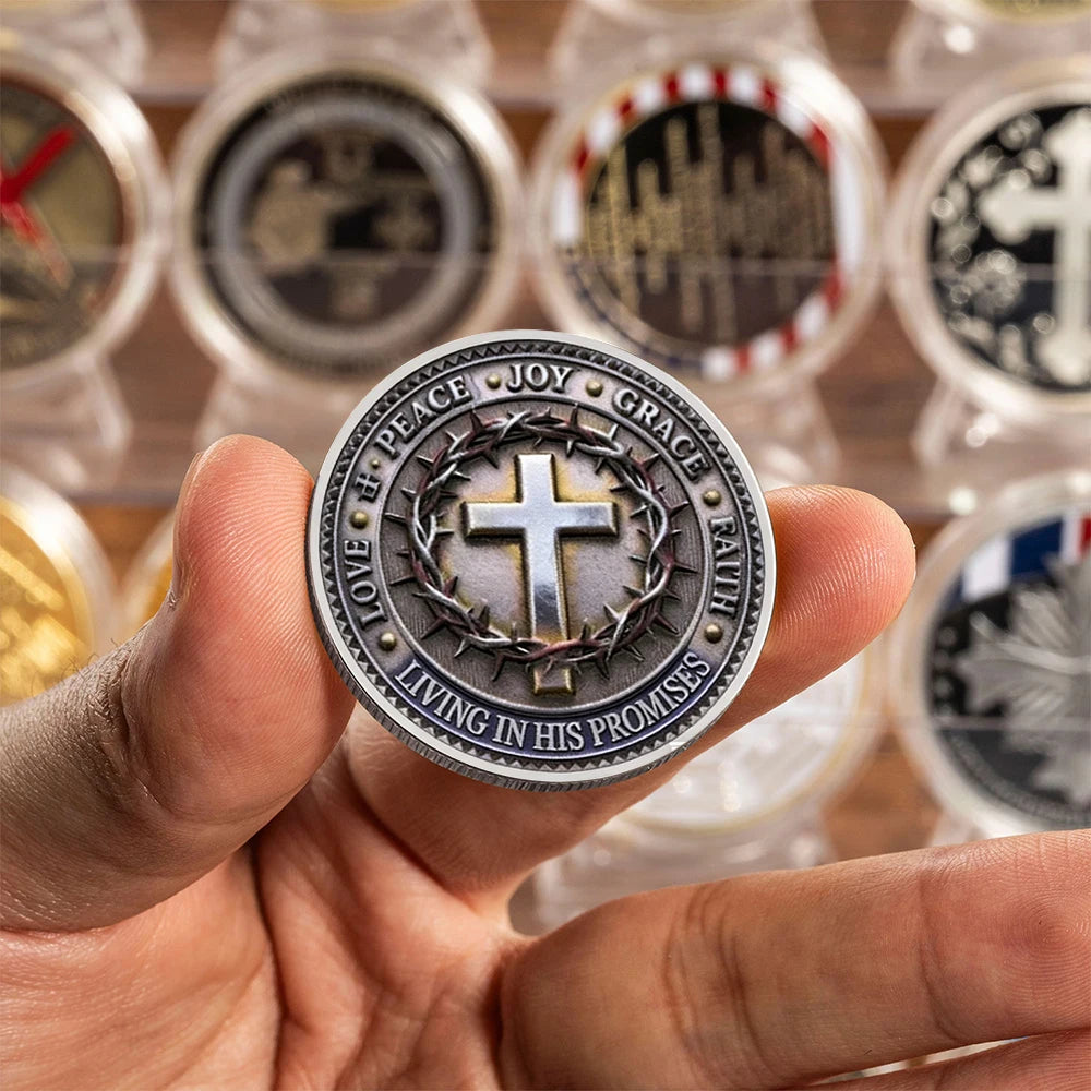 A hand holds a silvery commemorative faith cross coin surrounded by other similar coins.