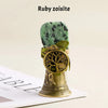 A natural crystal ruby zoisite specimen mounted on a brass bell with a copper finish.