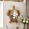 A golden sea turtle resin wall decor mirror mounted on a white wall.