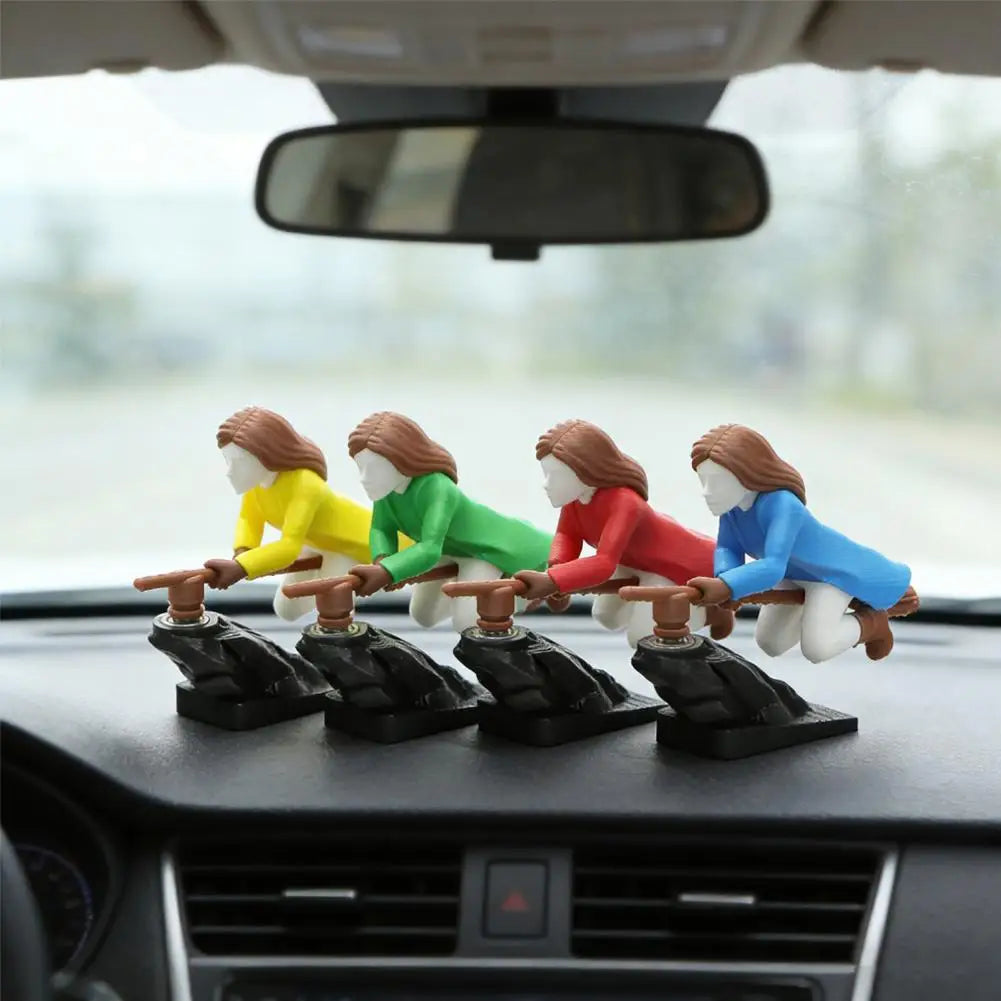A set of witch and wizard flying carriage dashboard drift decor figurines in various colors sitting on a car dashboard.