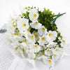 A bouquet of white artificial silk cloth flowers with green foliage.