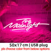 Neon sign displaying The Midnight in bright pink light against a textured background.