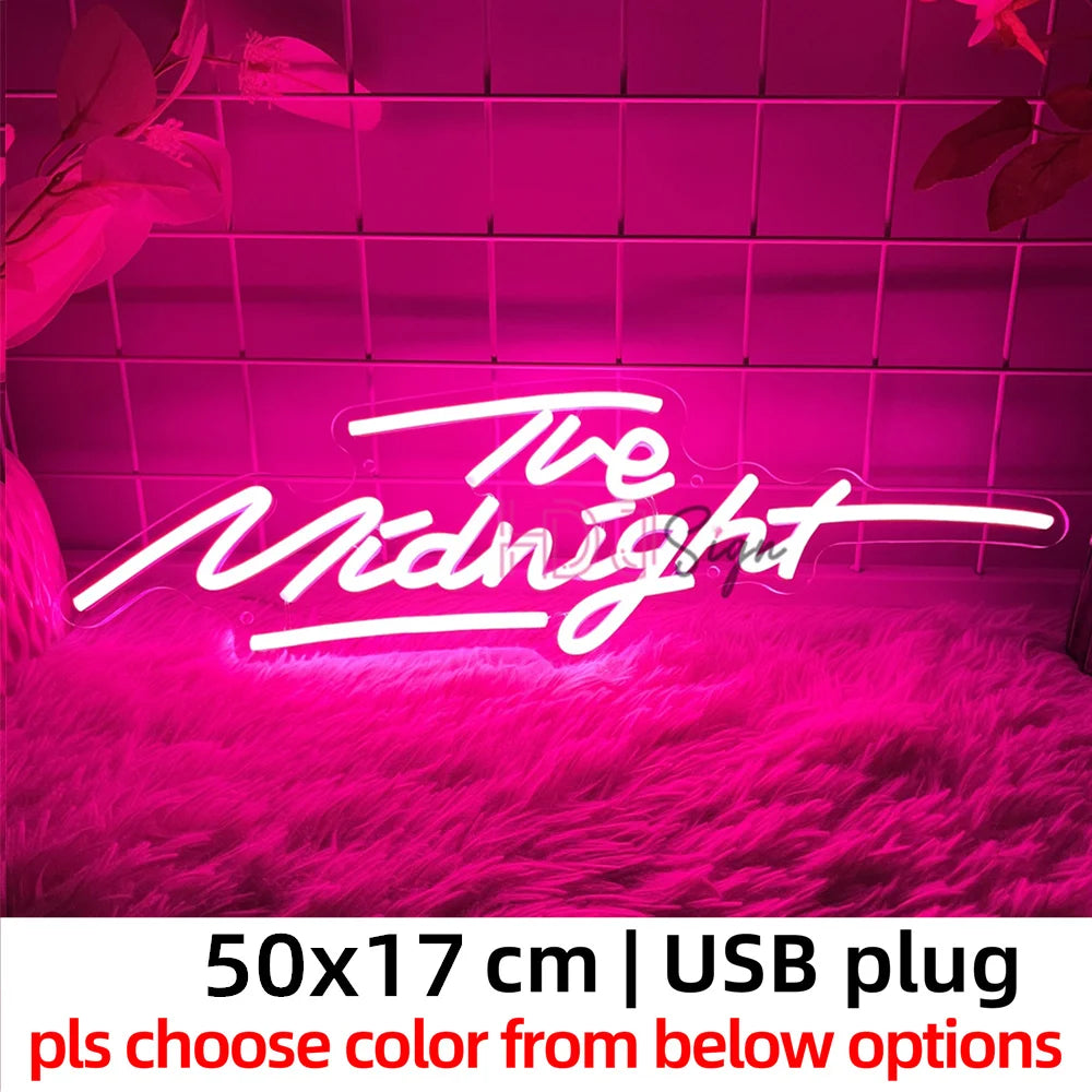 Neon sign displaying The Midnight in bright pink light against a textured background.