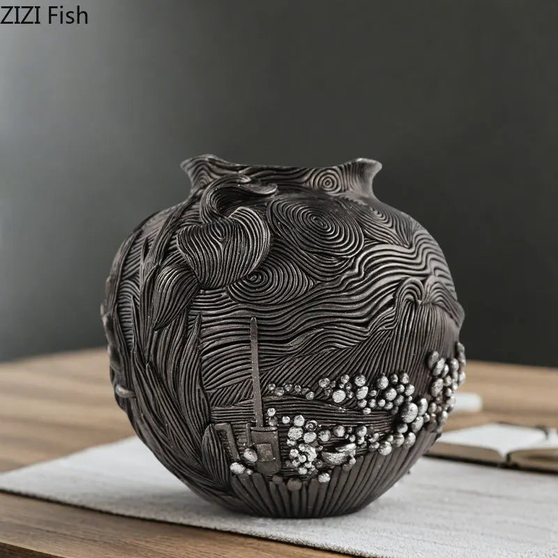 A dark gray resin vase with intricate swirling patterns sits on a wooden surface.