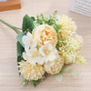A bouquet of artificial silk peony flowers in shades of cream and yellow with green foliage.