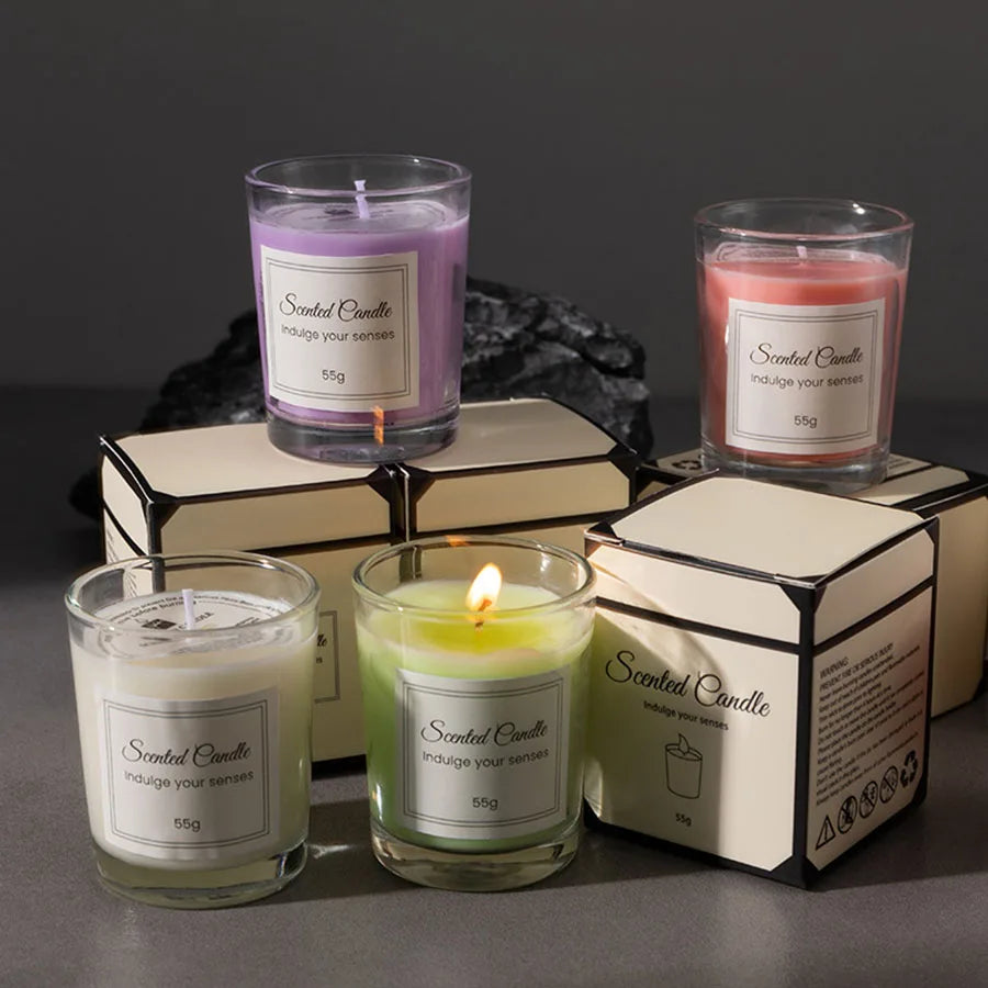 A collection of scented candles in glass jars and boxes featuring purple, pink, and green wax.