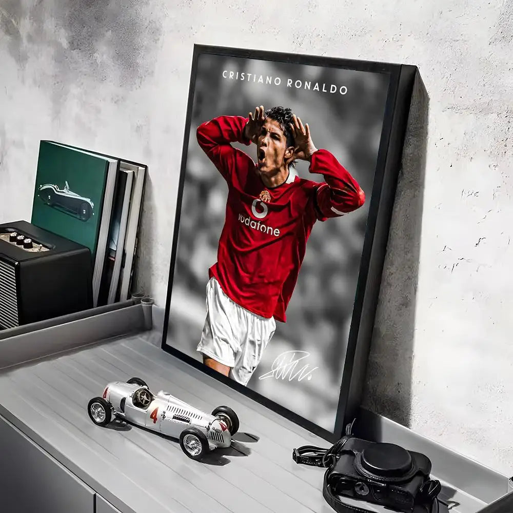 A framed poster of Cristiano Ronaldo in a red shirt, displayed on a gray shelf.
