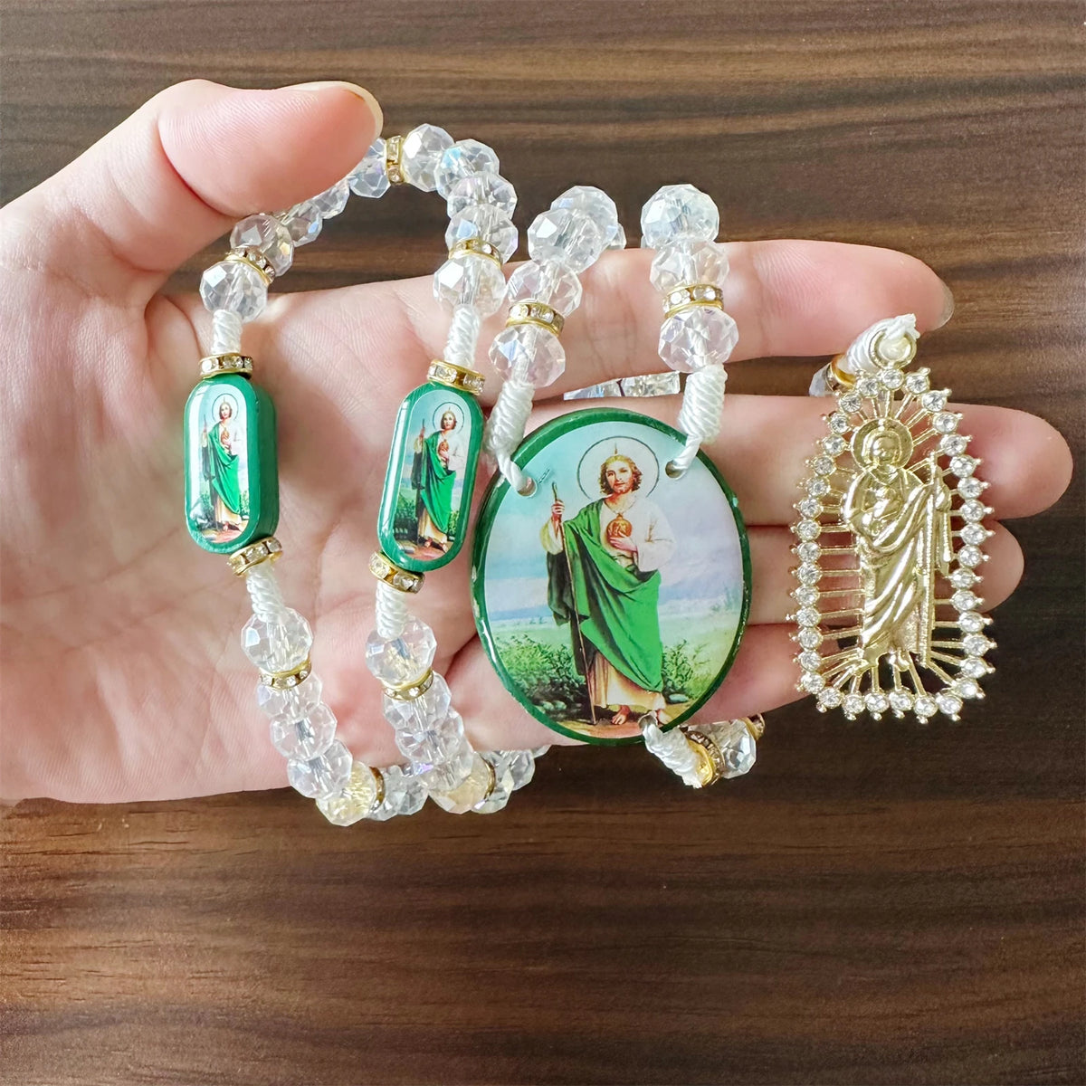 A green crystal rosary necklace featuring a Saint Jude and Virgin Mary cross pendant.