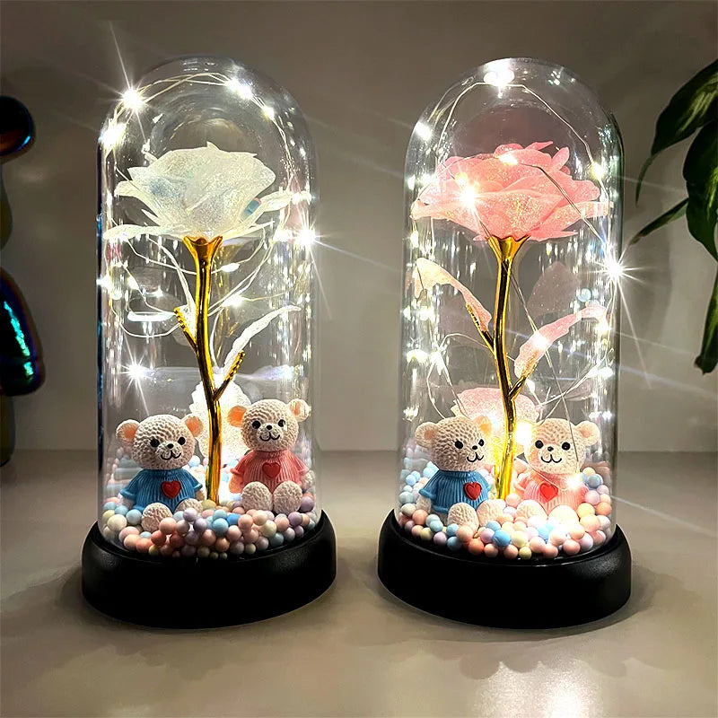Dos flores de rosa de plástico decorativas encapsuladas en vidrio con efectos de luz brillante sobre una base negra