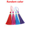 A collection of colorful bamboo folding fans with decorative pendants, including red, pink, blue, and purple.