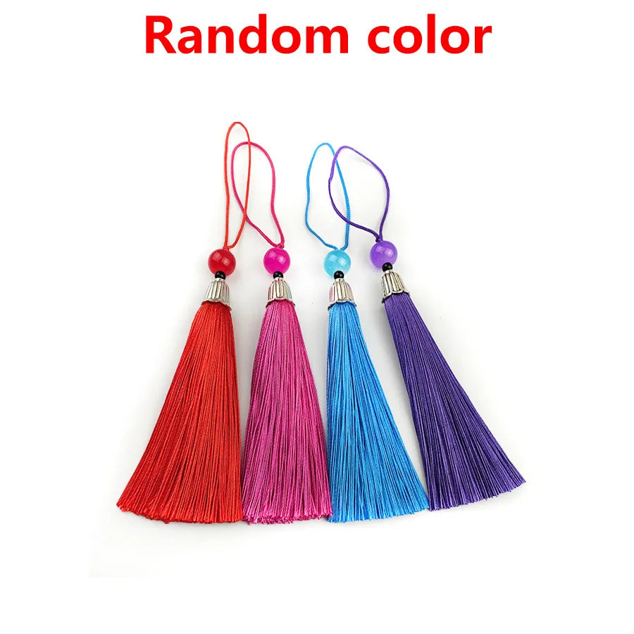 A collection of colorful bamboo folding fans with decorative pendants, including red, pink, blue, and purple.