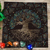 A dark fabric cloth featuring a gold-toned tree silhouette with vibrant blue and green foliage, surrounded by decorative flor