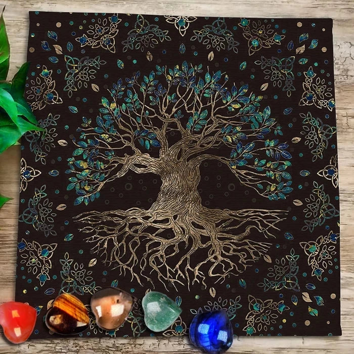 A dark fabric cloth featuring a gold-toned tree silhouette with vibrant blue and green foliage, surrounded by decorative flor