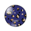 A round glass cabochon with a dark blue background featuring irregular leopard print patterns in black and tan.
