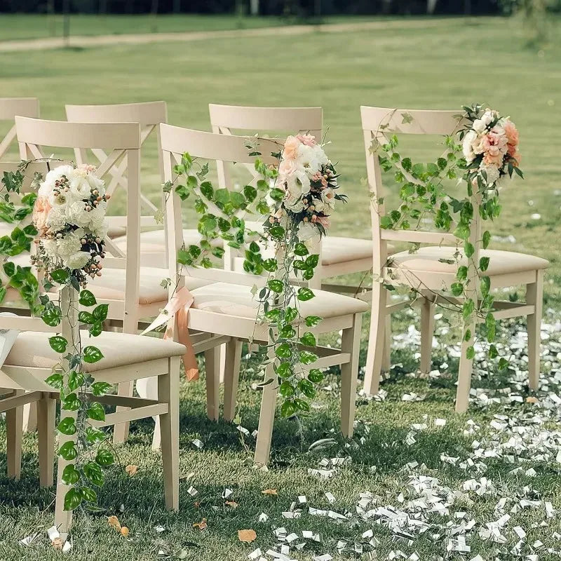 Wedding ceremony chairs decorated with artificial ivy vine garlands and floral accents on a grassy lawn