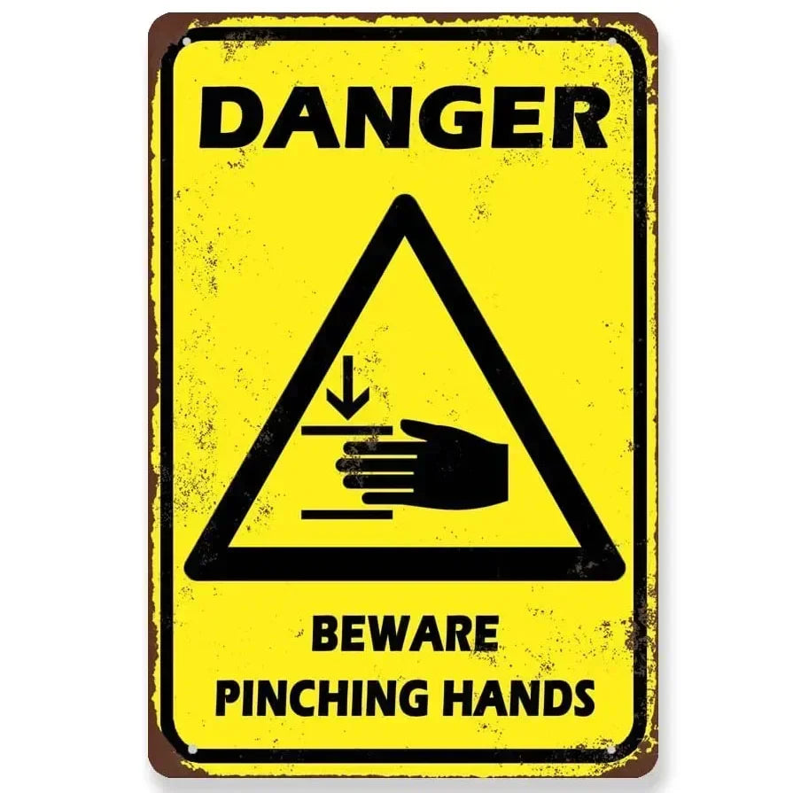Vintage yellow and black warning sign indicating danger and to beware of pinching hands