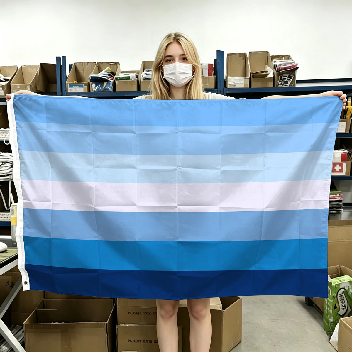 A person holds up a horizontal blue, white, and light blue striped flag banner.