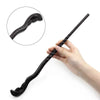 A hand holds a black, serpentine metal-resin magic wand with a curved tip.