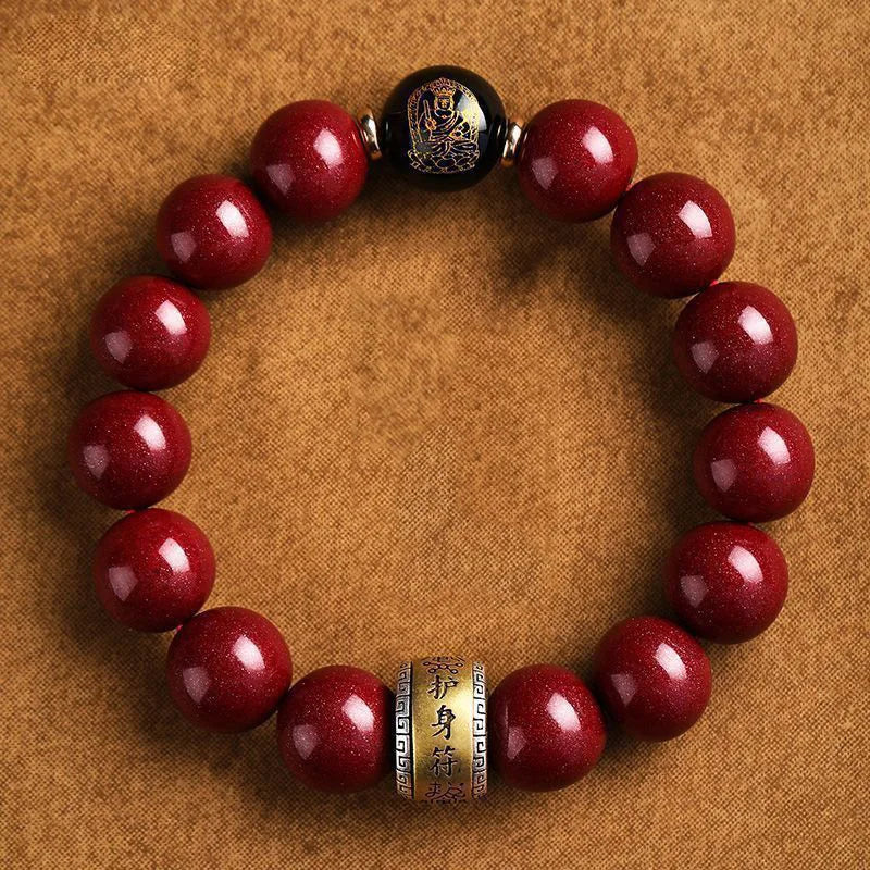 A bracelet made of polished red cinnabar stones, featuring an engraved charm.