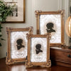 A set of three ornate gold-framed resin photo frames featuring silhouette designs on white backgrounds.