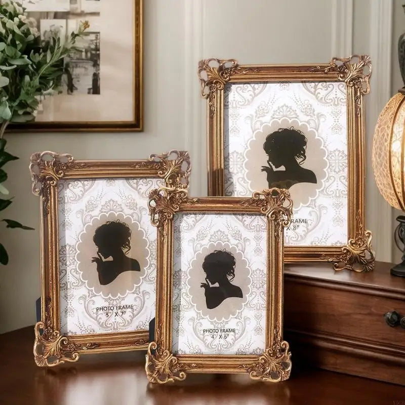 A set of three ornate gold-framed resin photo frames featuring silhouette designs on white backgrounds.